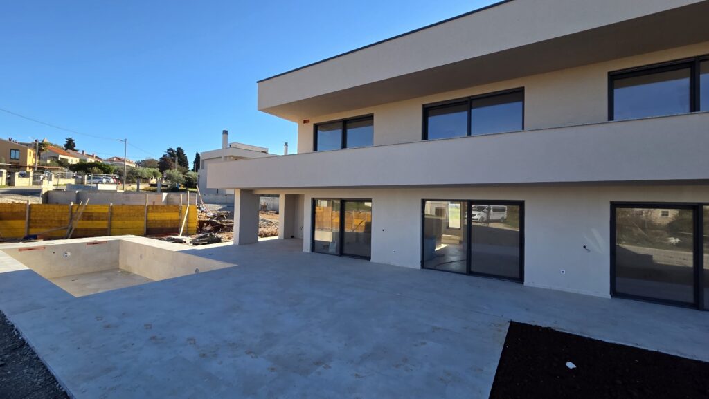 Luxury modern villa with swimming pool and large glass sliding doors, ideal for coastal living.