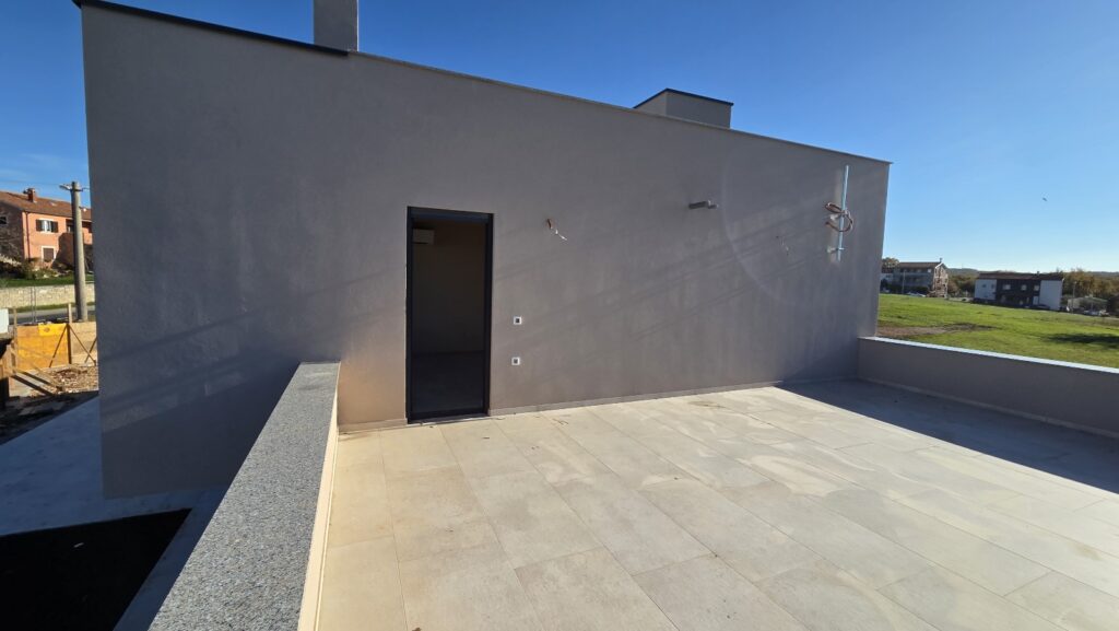 Modern house side entrance with clean lines and lawn.