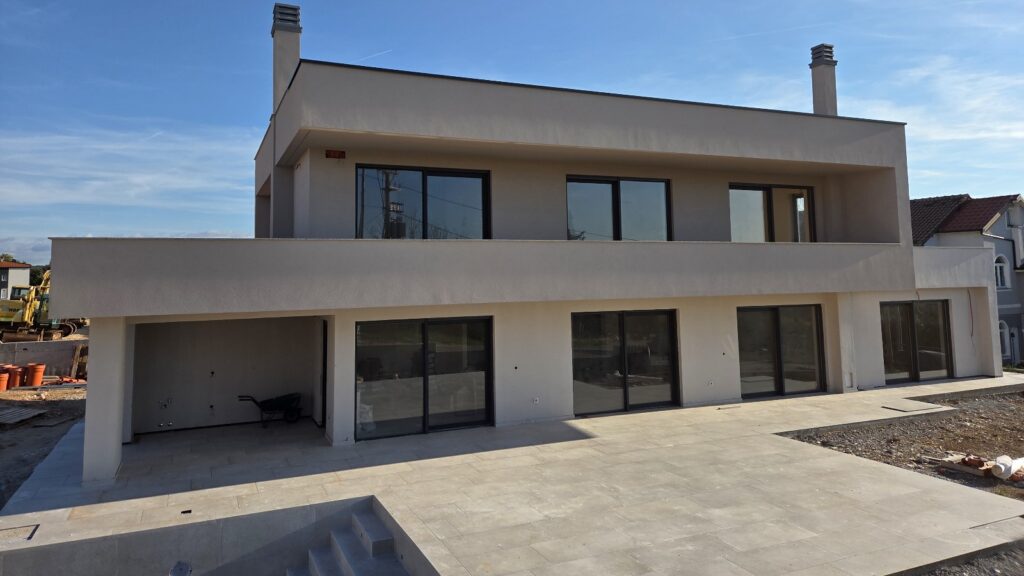 Luxury modern villa with swimming pool and large glass sliding doors, ideal for coastal living.